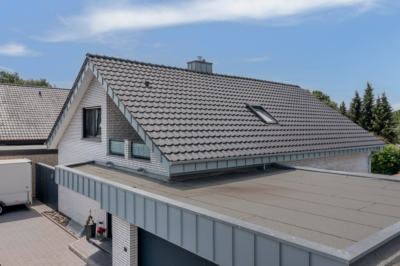 Beliebter Flachdachziegel J11v trifft auf klassischen Neubau mit angrenzender Garage.