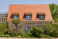 Landhotel mit Biberschwanzziegel Segmentschnitt in naturrot im Fokus das Nebengebäude.