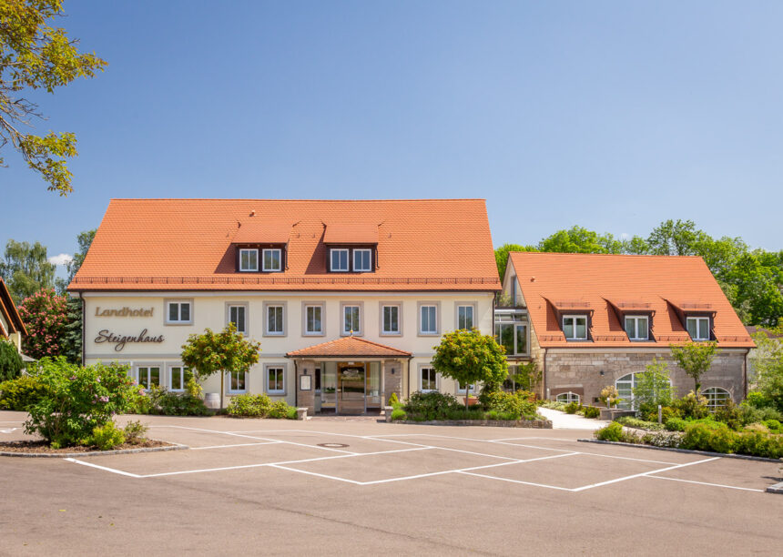 Landhotel mit Biberschwanzziegel Segmentschnitt in naturrot in der Gesamtansicht mit Nebengebäude.