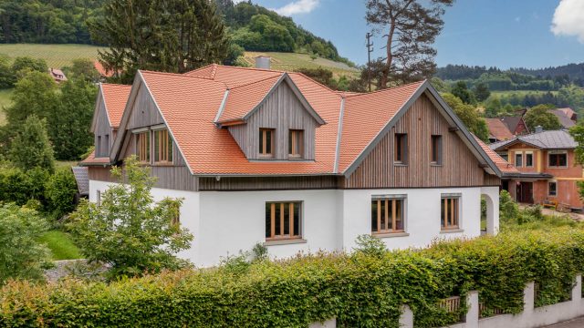 Saniertes Wohnhaus mit Biberschwanzziegeln Rundschnitt in natur plus. Auf dem Foto die schräge Gesamtansicht.
