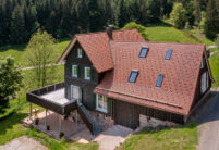 Typisches Schwarzwaldhaus mit geflammten Biber im Fokus die Rundholzhalterung aus der Luft fotografiert.