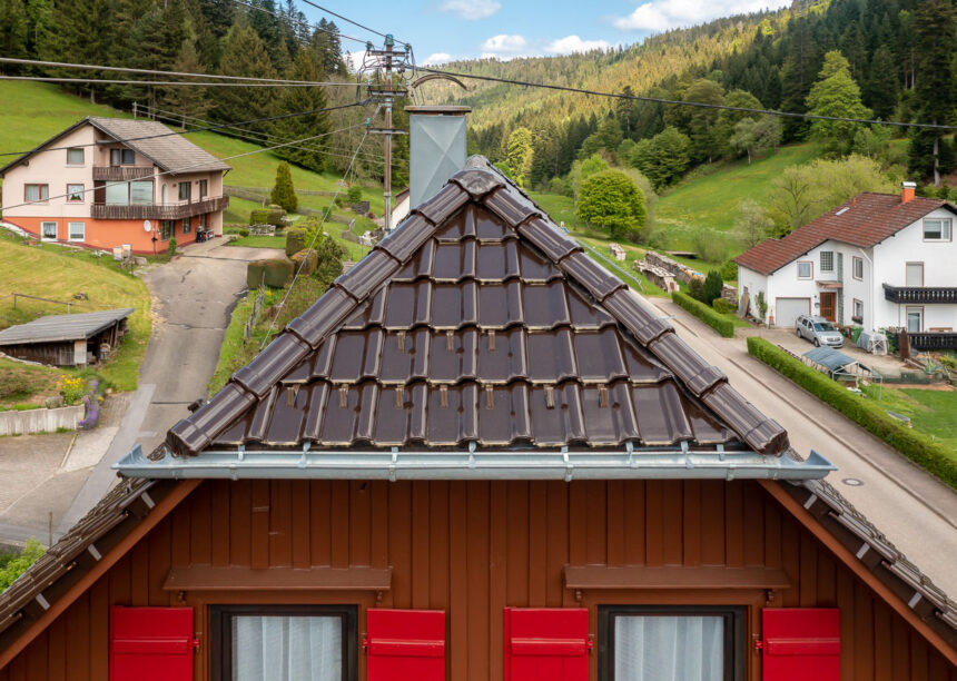 Krüppelwalmdach mit J11v in edelbraun auf saniertem Wohnhaus mit 3-achsige Walmkappe und Grad samt Anfänger im Bild.