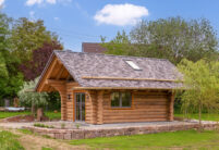 Holzhaus mit Biberschwanzziegeln in effektgrau in Komplettansicht.