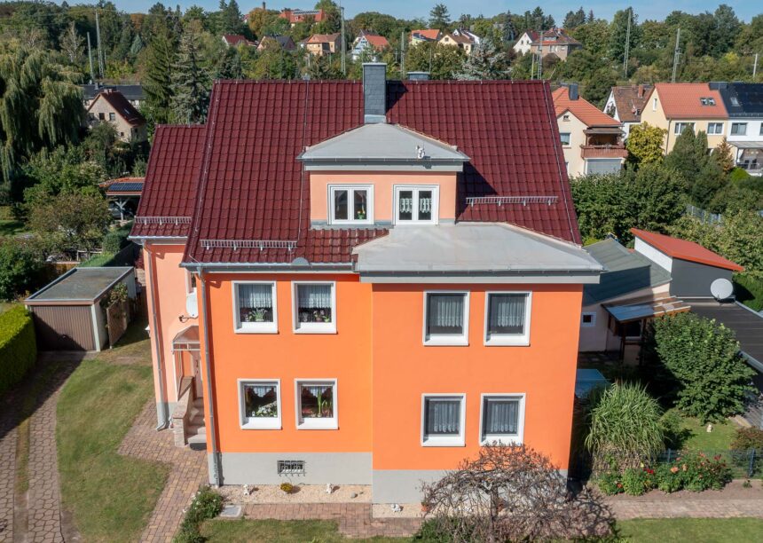 Mehrfamilienhaus mit J11v in edelweinrot in der Gesamtansicht.