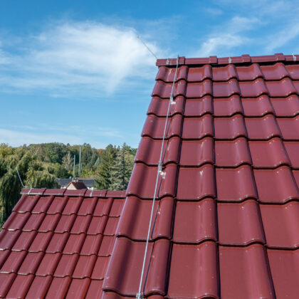 Mehrfamilienhaus mit J11v in edelweinrot hier mit Fokus auf den seitlichen Dachabschluss.