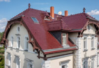 Denkmalgeschützte Villa mit bordeauxroten Biberschwanzziegeln mit der Giebelseite und Dachfläche im Bild.