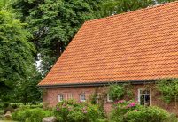 Friesisch-bunt Salzbrand auf historischen Klinkerhaus mit Krüppelwalmdach hier mit tollem Garten