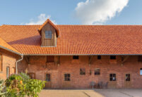 Bauernhof mit friesisch-bunt Salzbrand auf dem Dach mit Fokus auf die holzverkleidete Gaube