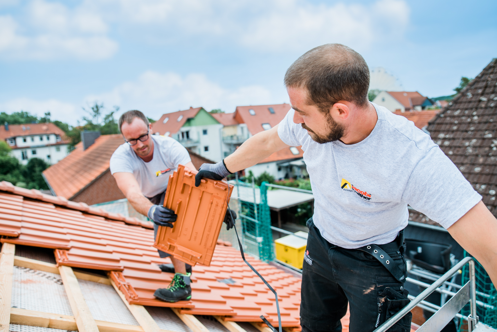 Dachdecker bei der Eindeckung von Tondachziegel auf dem Dach