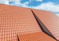 Sanierter Bauernhof mit Flachdachziegel W6v in rotbraun