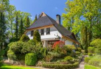 Traditionelles Einfamilienhaus mit Krüppelwalmdach, gedeckt mit Biberschwanzziegel in edelschwarz