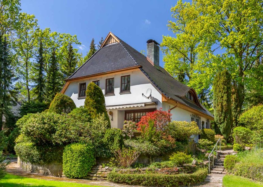 Traditionelles Einfamilienhaus mit Krüppelwalmdach, gedeckt mit Biberschwanzziegel in edelschwarz