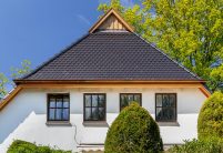 Traditionelles Einfamilienhaus mit Krüppelwalmdach, gedeckt mit Biberschwanzziegel in edelschwarz