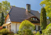 Traditionelles Einfamilienhaus mit Krüppelwalmdach, gedeckt mit Biberschwanzziegel in edelschwarz