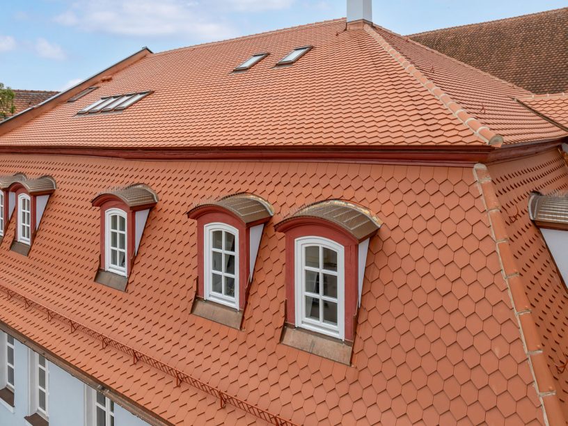 Mehrfamilienhaus mit Bibern in Rautespitz im traditionellen naturrot gedeckt mit Fokus auf die kunstvollen Gauben
