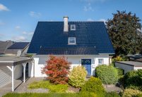 Satteldach mit Flachdachziegel J13v in marineblau in der Gesamtansicht mit Garten Carport und Garten