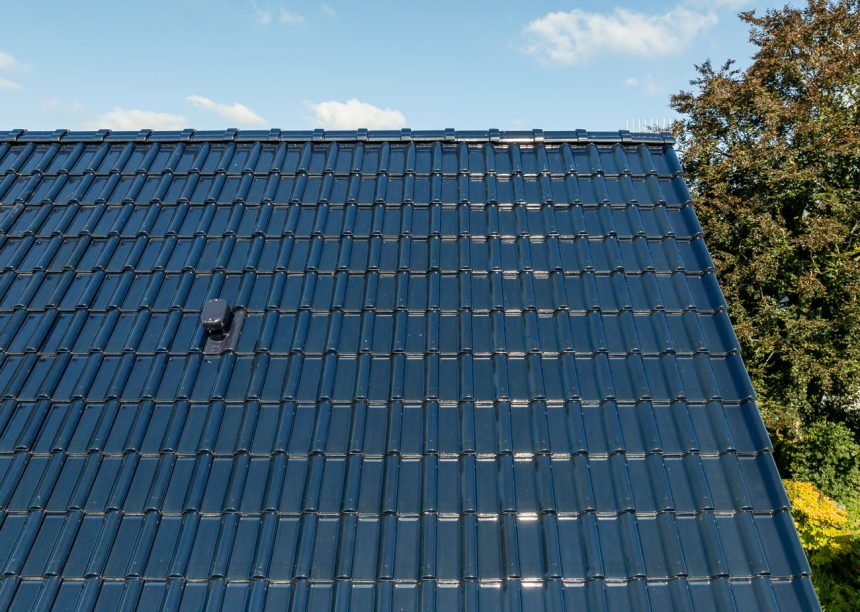Satteldach mit Flachdachziegel J13v in marineblau mit Fokus auf das schöne Deckbild