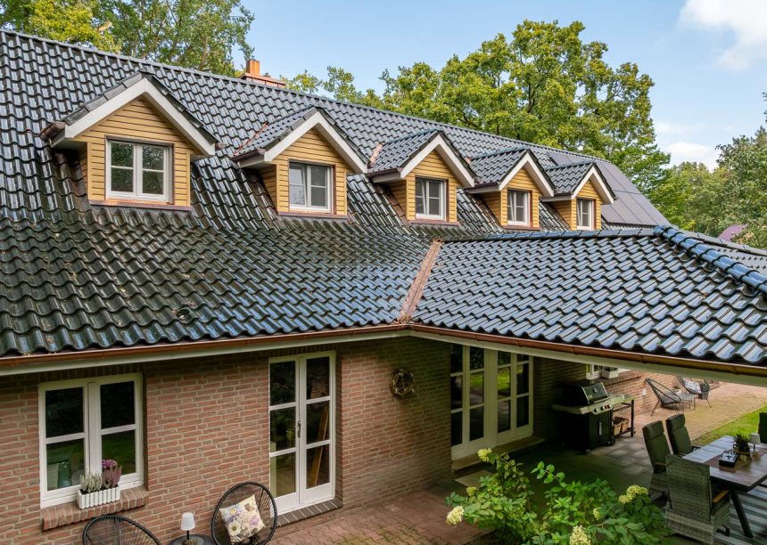 Hohlfalzziegel Z5 in tannengrün mit tollem Deckbild, Schwung auf dem Dach. Bildfokus auf die Gauben und Terrassenüberdachung