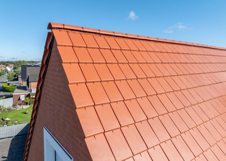 Naturrote Flach-Dachziegel auf Mehrfamilienhaus mit Klinkergiebel und Zubehör Ortgang im Fokus