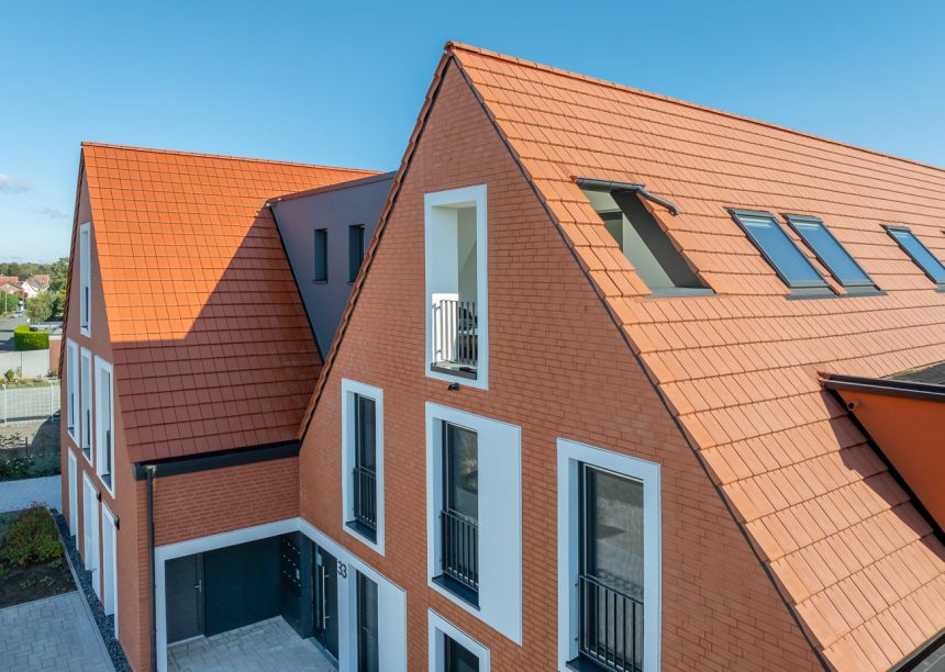 Naturrote Flach-Dachziegel auf Mehrfamilienhaus mit Klinkergiebel