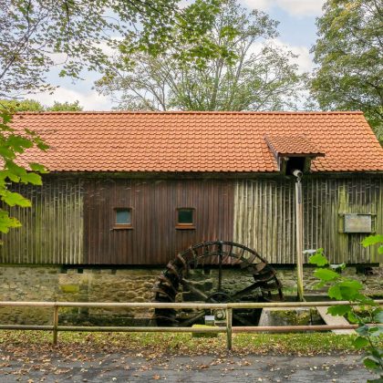 Schneidmühle der Stadt Steinach mit Fokus auf das Mühlrad und auf dem Dach der Zietgel K1 in naturrot
