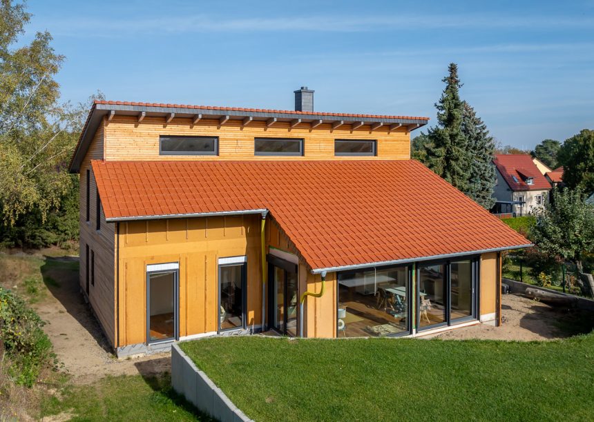 Garteneinblick von Einfamilienhaus mit Dachziegel J160 in altrot mit schöner Holzfassade