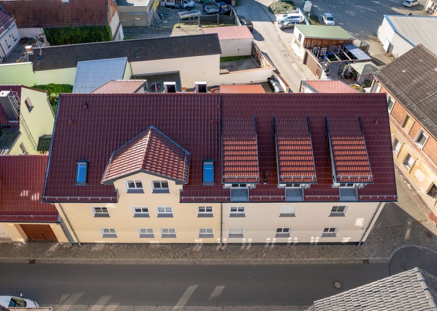 Vogelperspektive von Mehrfamilienhaus mit Tonziegel J11v in der Edelengobe edelkupfer