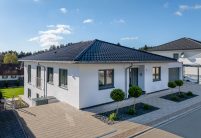 Unser beliebtester Dachziegel J11v hin im stylischen spacegrau auf Bungalow mit Walmdach von der Straßenansicht aus fotografiert mit modernem Vorgarten