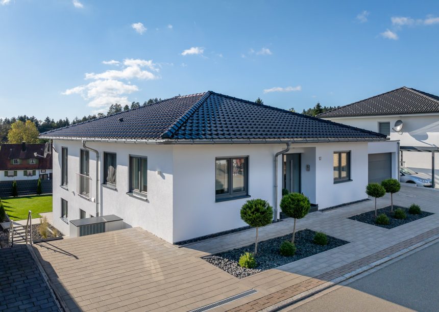 Unser beliebtester Dachziegel J11v hin im stylischen spacegrau auf Bungalow mit Walmdach von der Straßenansicht aus fotografiert mit modernem Vorgarten