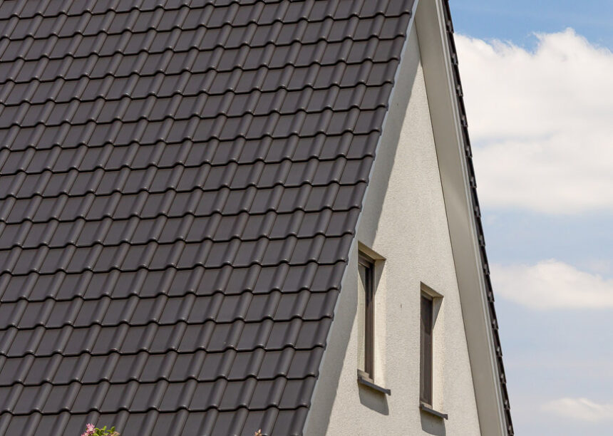 Klassisches Einfamilienhaus mit zeitlosem Flachdachziegel J11v mit Blick auf die rechte Giebelseite.