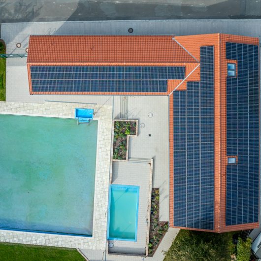 Trendziegel J160 im klassischen Rotton altrot auf Schwimmbad in Northeim aus der Vogelperspektive fotografiert mit PV-Anlage und PV-Zubehör von Jacobi und K2