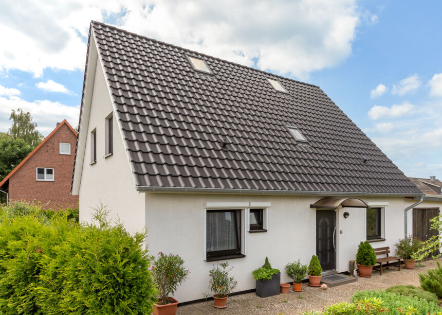 Klassisches Einfamilienhaus mit zeitlosem Flachdachziegel J11v. Hier abgebildet das Steildach und der Eingangsbereich.