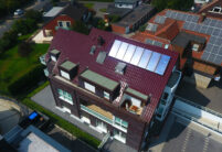 Mehrfamilienhaus aus der Vogelperspektive mit Flachdachziegel J11v in edelweinrot hier in der Gesamtansicht.