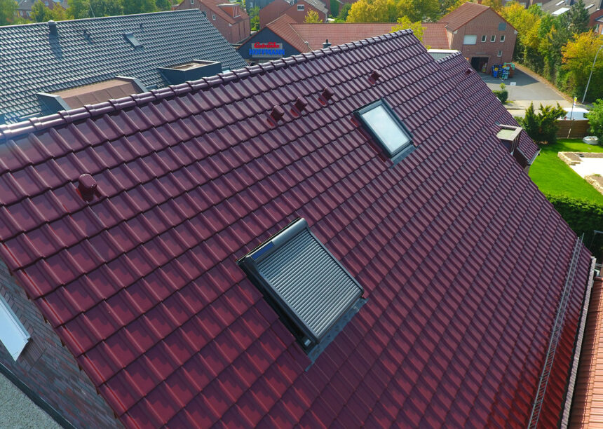 Mehrfamilienhaus aus der Vogelperspektive mit Flachdachziegel J11v in edelweinrot. Im Fokus das tolle Deckbild.