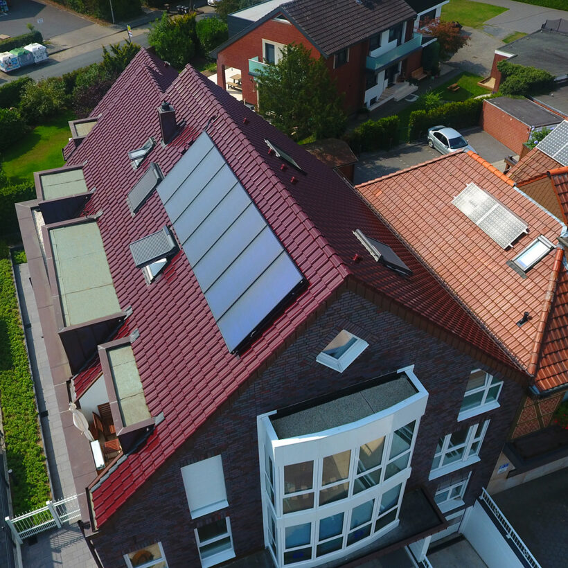 Mehrfamilienhaus aus der Vogelperspektive mit Flachdachziegel J11v in edelweinrot.