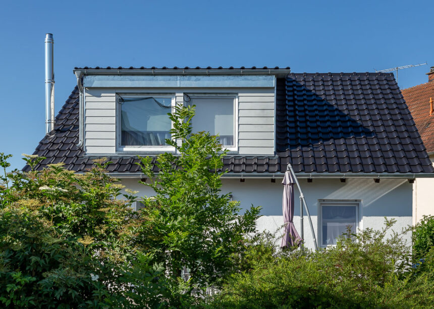 Klassisches Einfamilienhaus mit holzvertäfelter Gaube und J11v-Dach in edelschwarz.