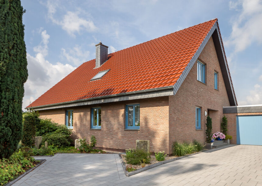 Auf dem Steildach unsere Flachdachpfanne J11v in edelkupfer. Auf diesem Foto das gesamte Haus mit Einfahrt.