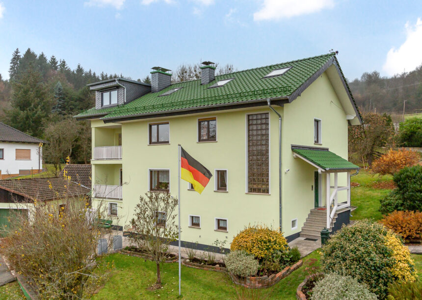 Sanierter Bau aus den 70/80er Jahren mit auffallend grünem Dach und gleichfarbigem Schneefanggitter.