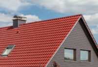 Saniertes Einfamilienhaus mit strahlend rotem Dach und Firstanfänger für Satteldach im Fokus