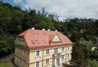 Biber im Rundschnitt in der Oberfläche romantik zaubert ein tolles Farbspiel auf das Krüppelwalmdach, hier mit Blick auf den Balkon und Eingangsbereich