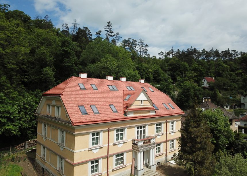 Biber im Rundschnitt in der Oberfläche romantik zaubert ein tolles Farbspiel auf das Krüppelwalmdach, hier mit Blick auf den Balkon und Eingangsbereich