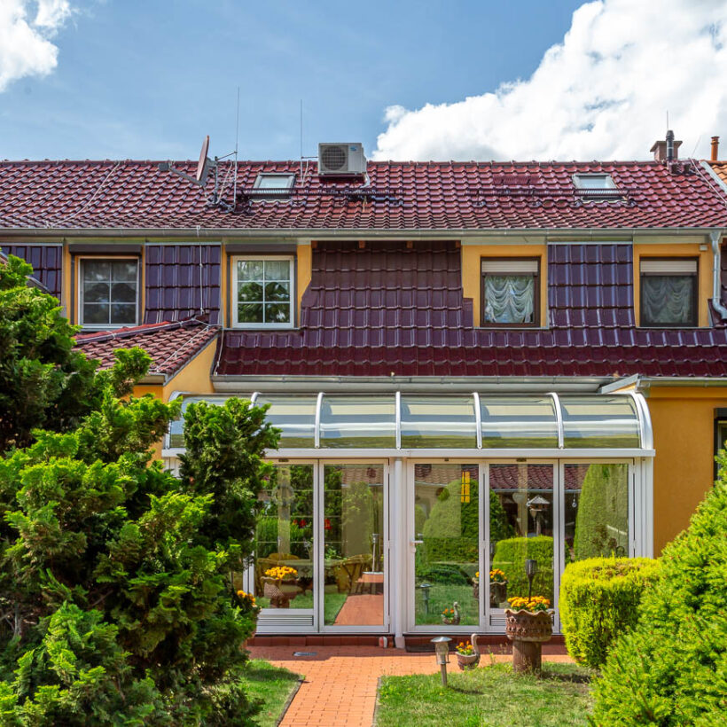 Wintergarten von Einfamilienhaus mit Flachdachziegel J11v in bordeauxrot gedeckt