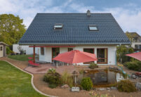 Klassisches Einfamilienhaus mit außergewöhnlich schönem J11v Dach in spacegrau frontal fotografiert aus der Gartenansicht