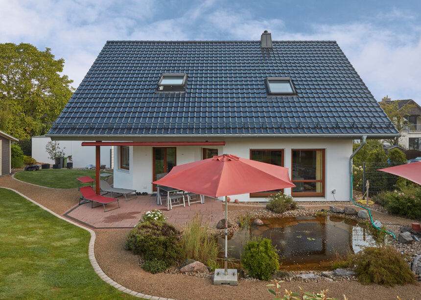 Klassisches Einfamilienhaus mit außergewöhnlich schönem J11v Dach in spacegrau frontal fotografiert aus der Gartenansicht