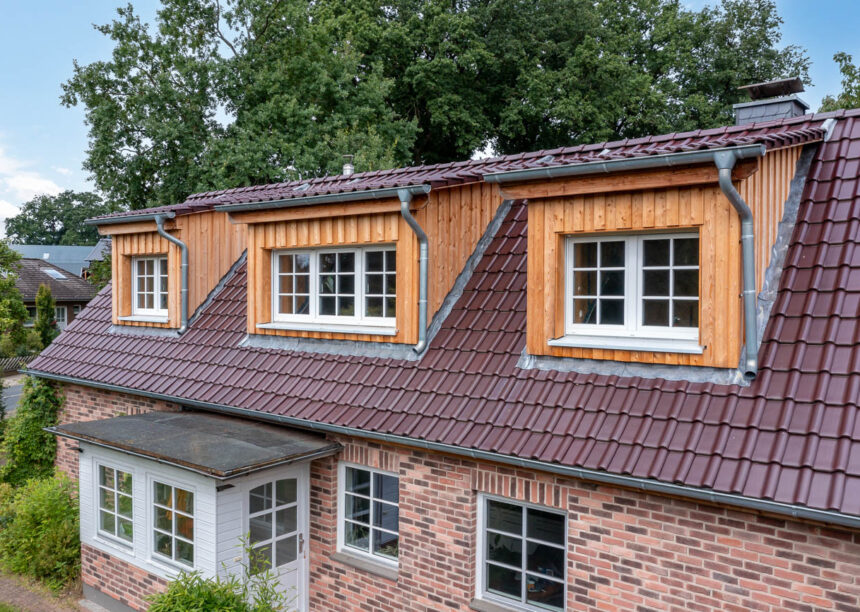 Glasur bordeauxrot matt auf Klinkerhaus mit Fokus auf die holzvertäfelten Gauben.