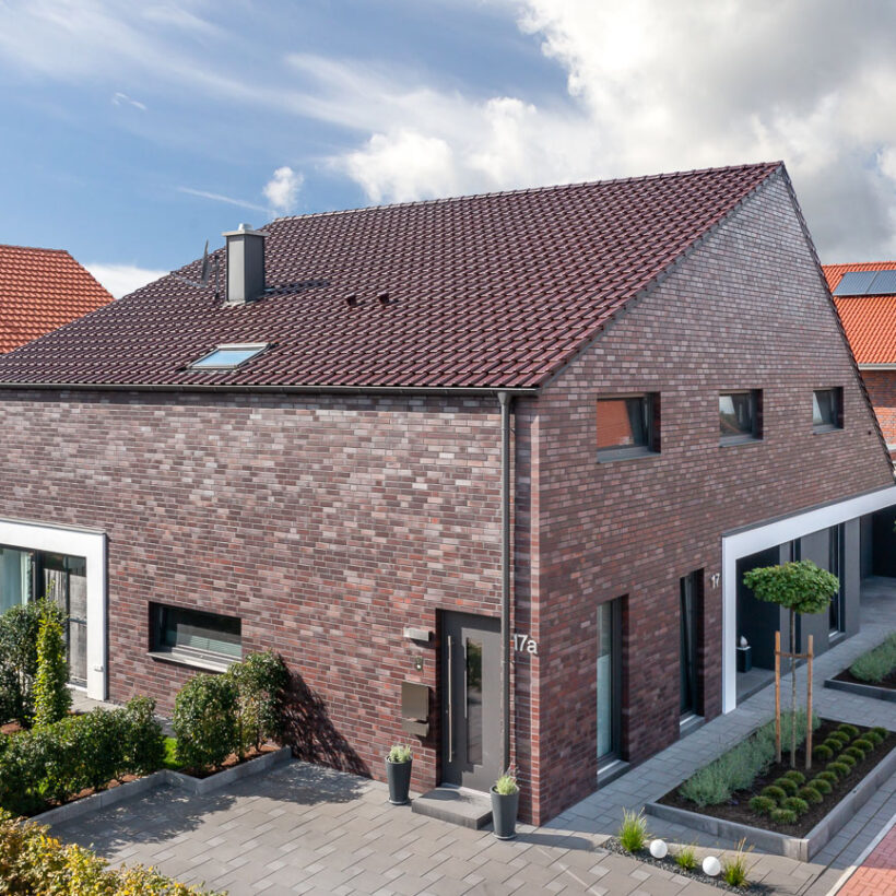 Einfamilienhaus mit Klinker, Flachdachziegel J11v in bordeauxrot matt auf dem Dach