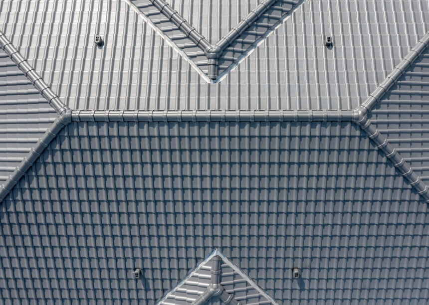 Aus der Vogelperspektive fotografiert: Dach eines Mehrfamilienhauses mit J11v in lavagrau matt und gleichfarbigem Firstziegeln