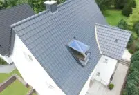 Vogelperspektive von Haus mit Dachterrasse und J11v Dach in der dezenten Glasur lavagrau matt
