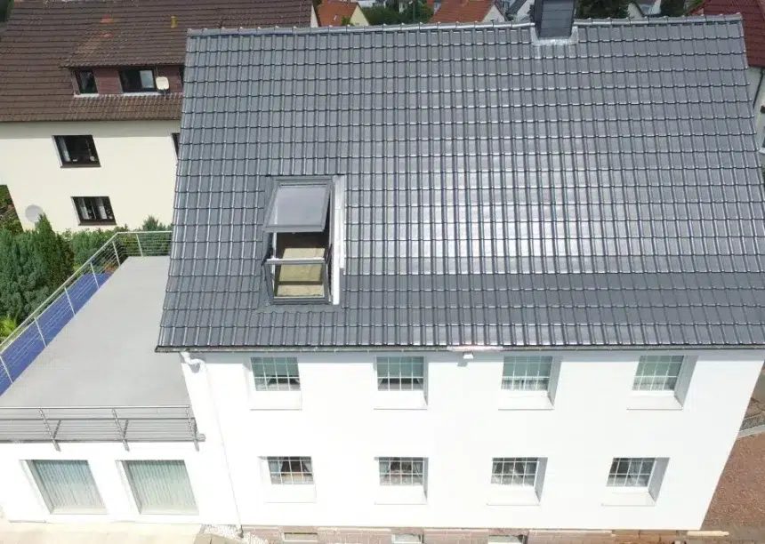 Vogelperspektive von Haus mit zwei Stockwerken und Dachterrasse und J11v Dach in der dezenten Glasur lavagrau matt