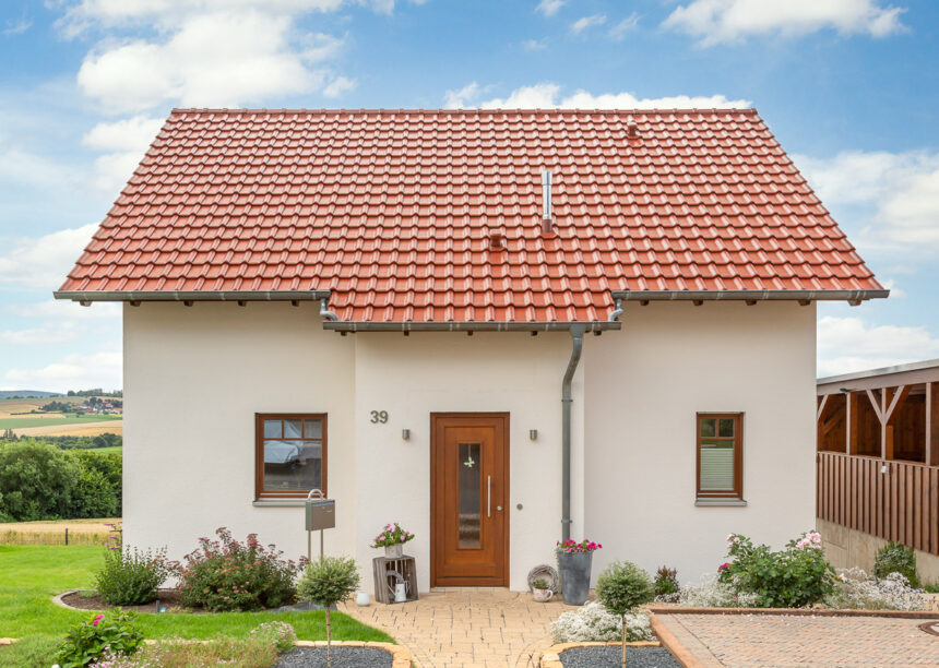 Einfamilienhaus mit Satteldach in toskanarot matt und Holztüre